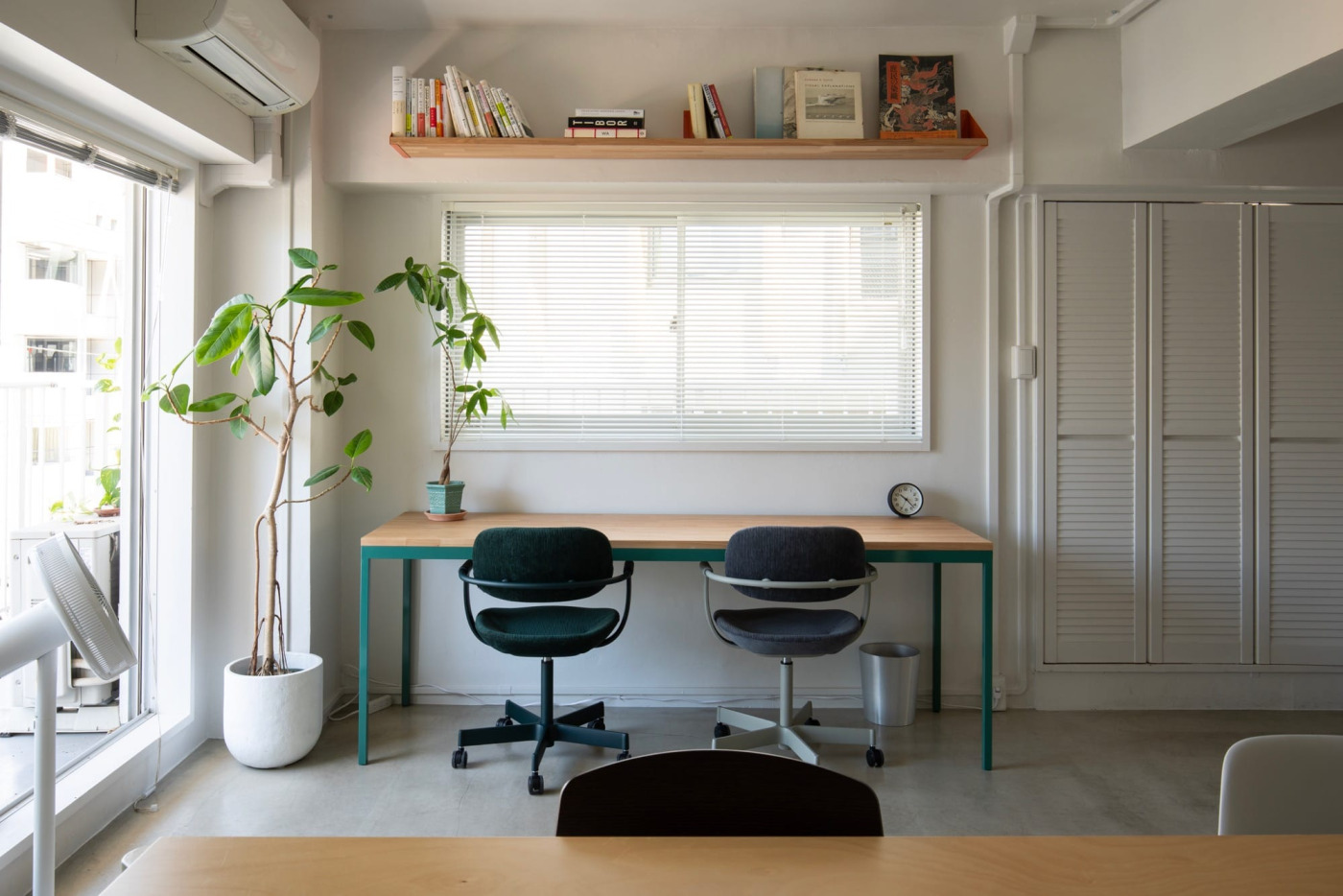 上部の棚板と樹種・幅を揃えてつくったデスク。白やグレーの内装にカラーや木の素材が良く映える。（角天板 タモ／面取り2mmR・T25・ツヤ消しウレタン塗装）
