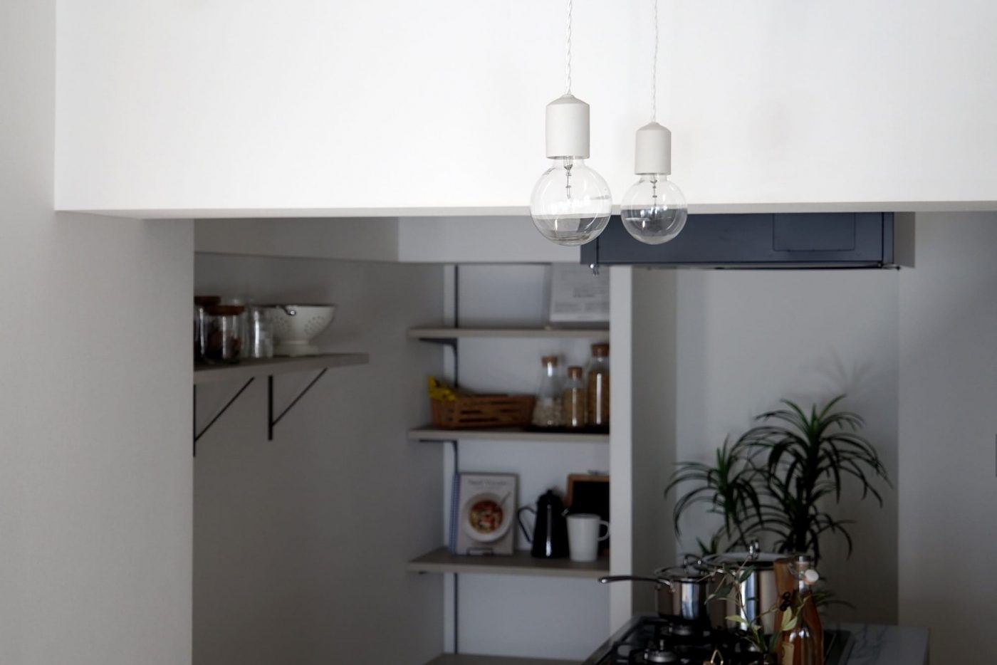 部屋の雰囲気に馴染ませた陶器の白マットをキッチンに2灯並べて。