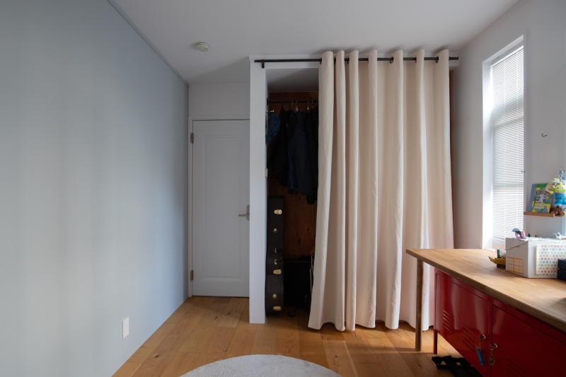 収納扉の代わりにハトメタイプを活用。柔らかな色味の中でブラックの「アイアンカーテンレール」が空間の引き締め役になっています。（アイボリー）
