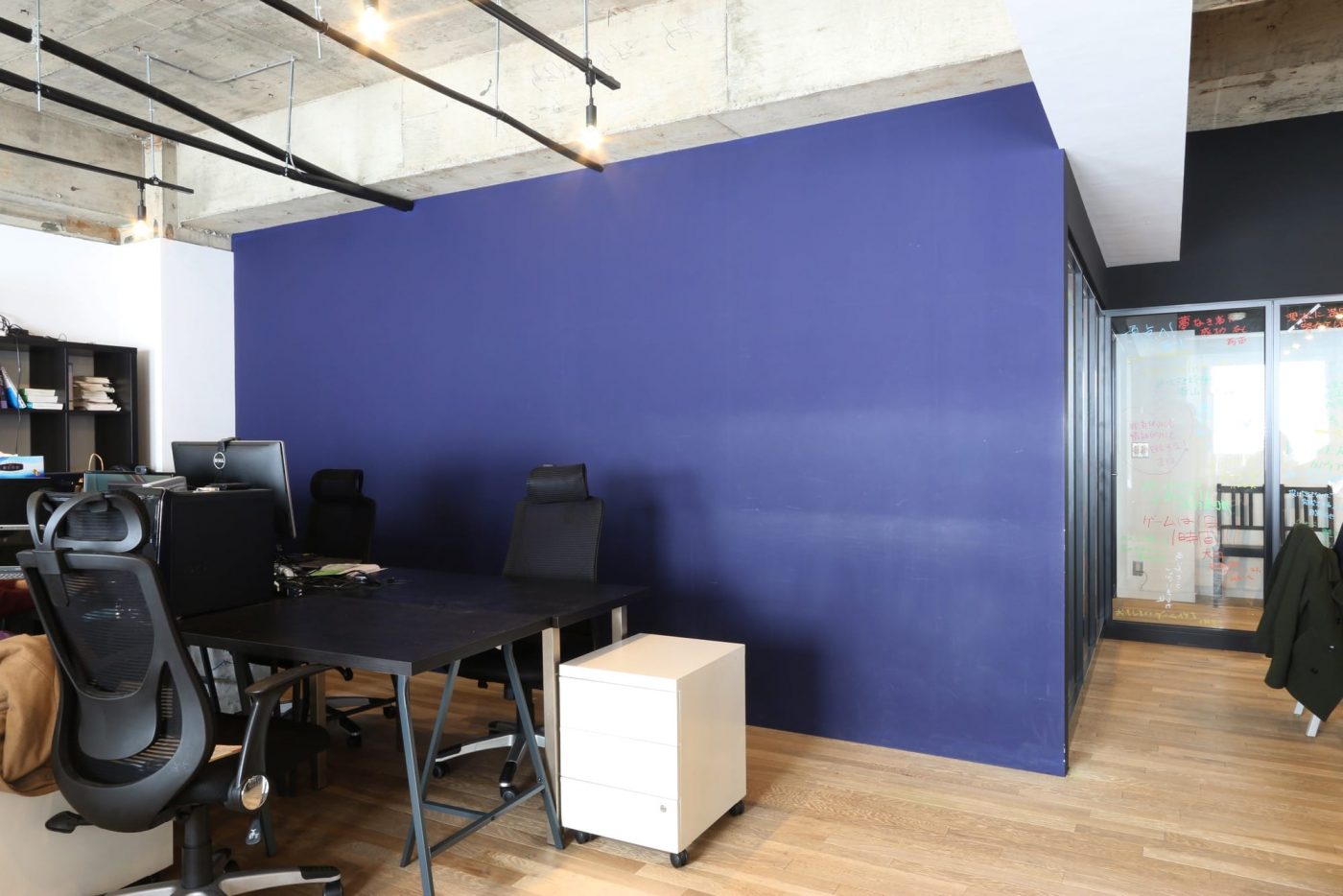 新たに造作したミーティングスペースを仕切る壁は、コーポレートカラーでカラーリング。