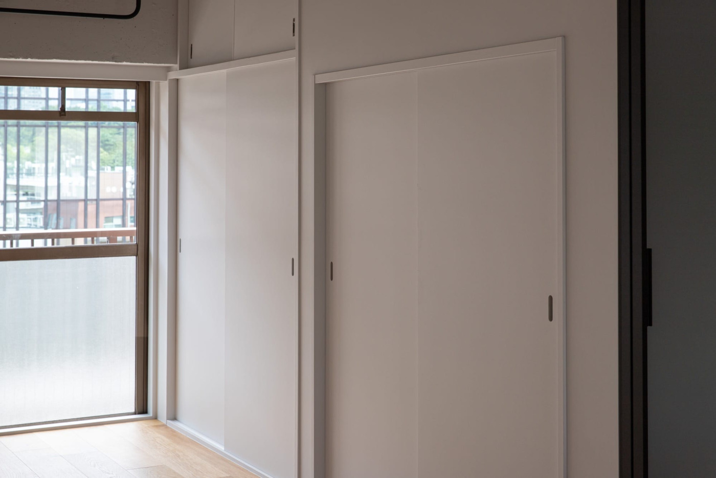 元々使われていた引き戸の枠に合わせて、扉を刷新。壁と一緒に白く塗装することで外からの光を室内に届けてくれる。（ラワン 白塗装）
