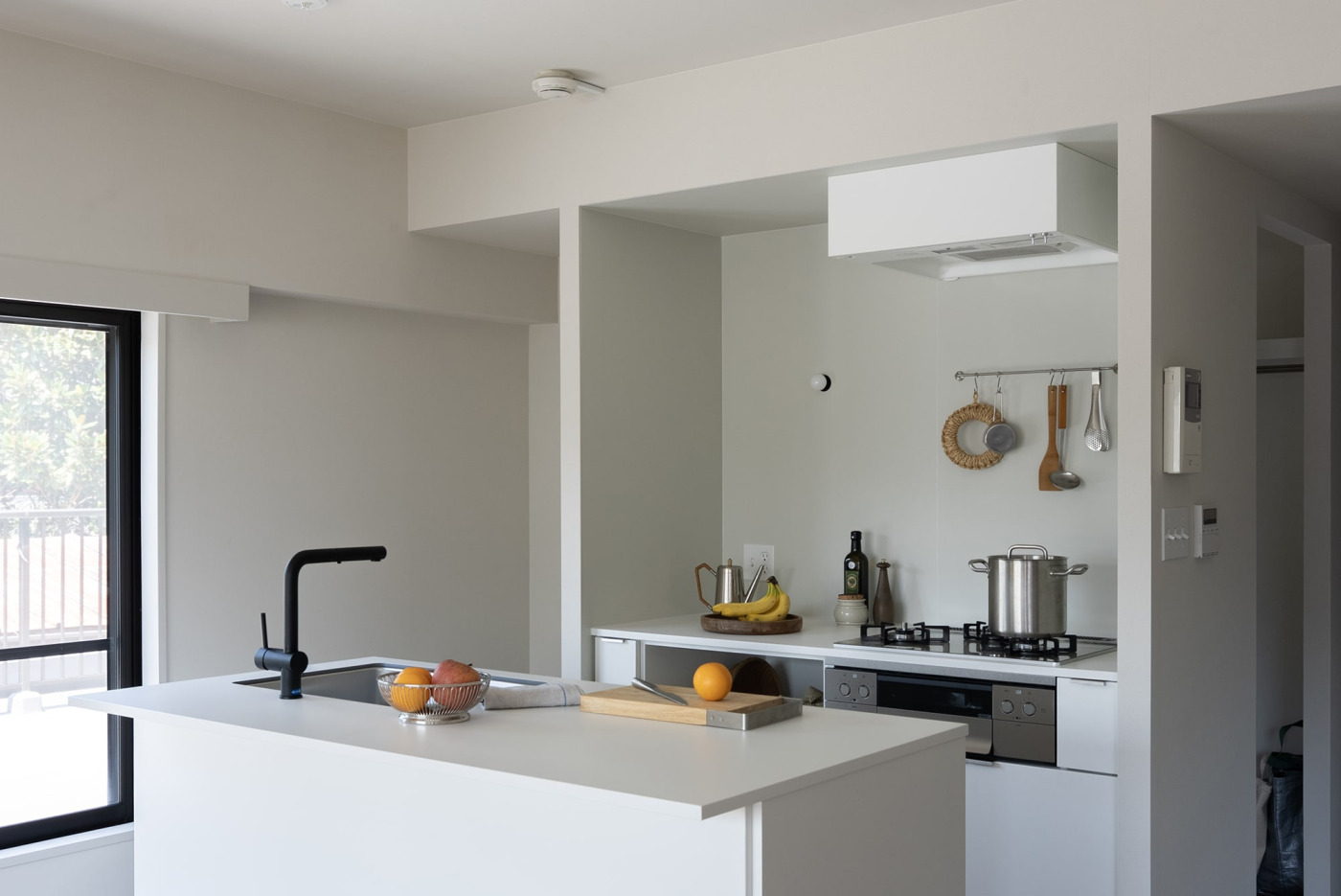 ホワイトを「マットカラーのキッチンパネル」（ライトグレー）と「マットカラーのキッチン天板」（見付20 オフホワイト）に合わせた事例。（壁付け型 W750 ホワイト）
