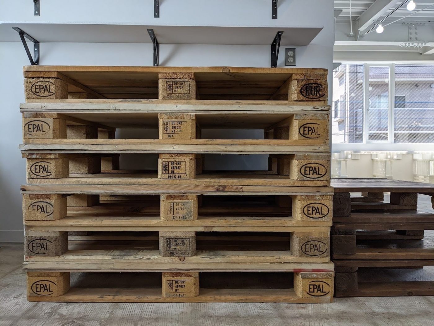 『パレット古材』の元の姿、積み重ねられた「木製パレット」が棚代わりに。