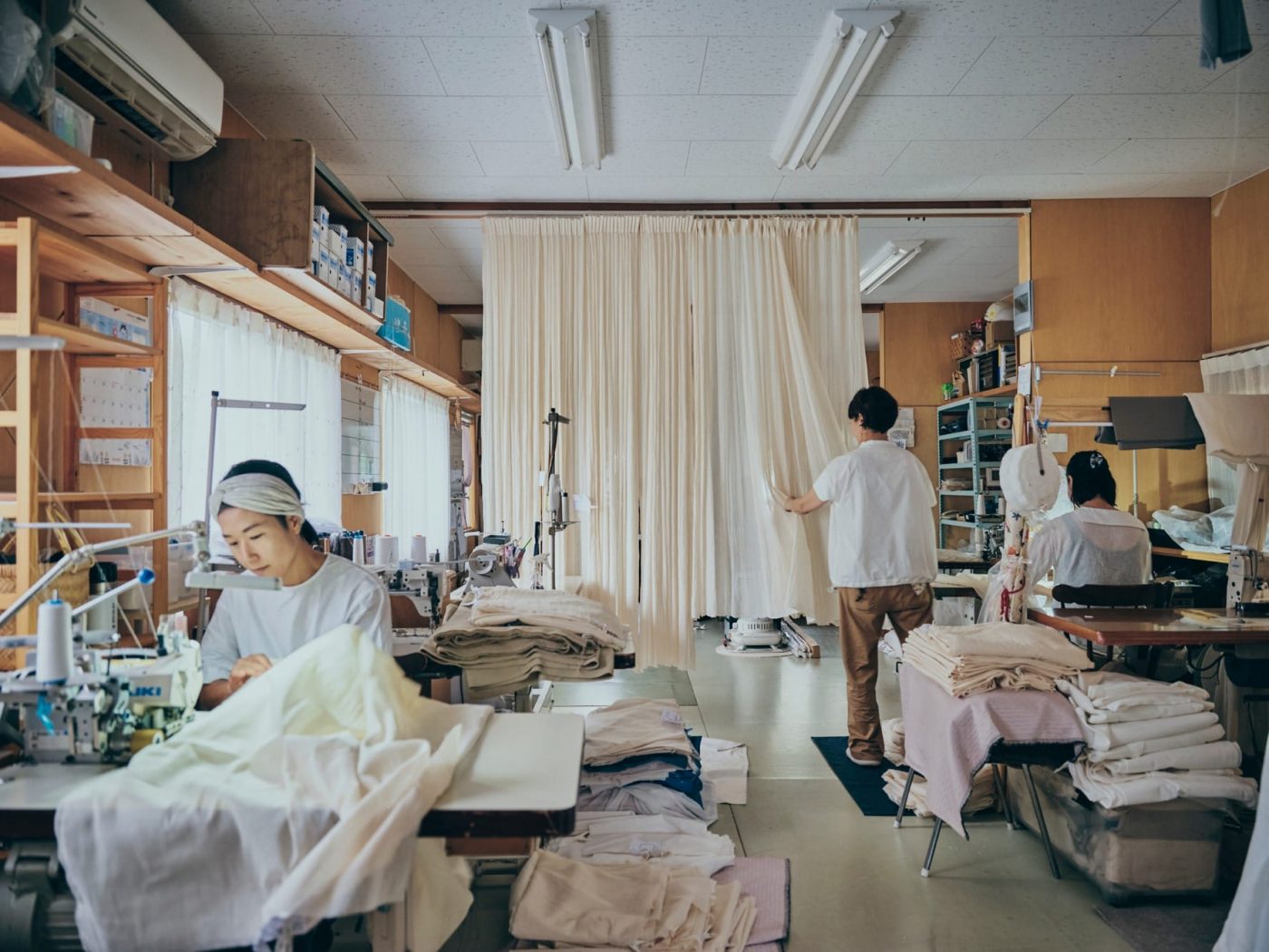 工房の中央にガーゼカーテンを吊って自然乾燥。乾き具合を佳織さんが手でチェックします。（撮影：Masanori Kaneshita）