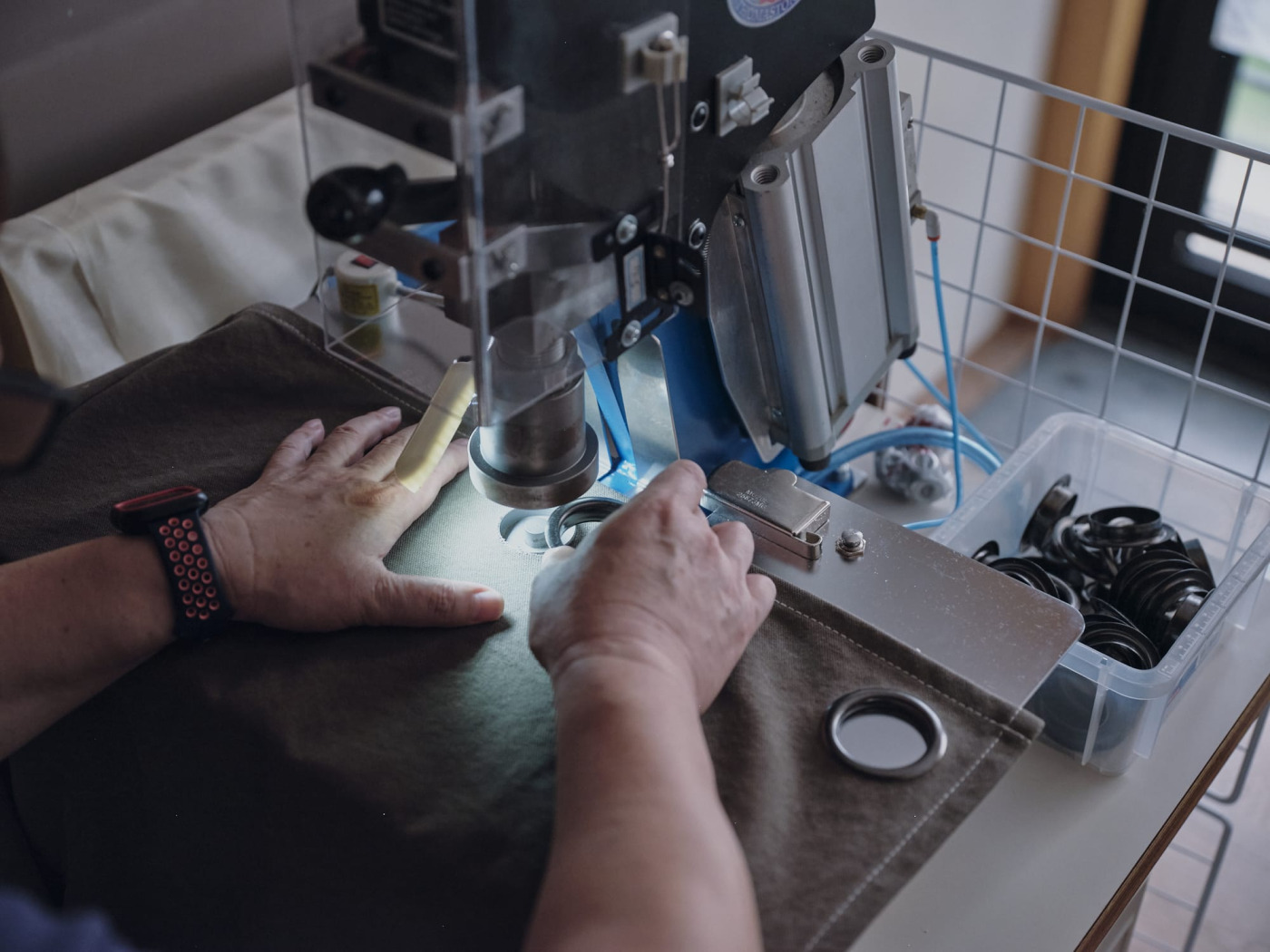 力仕事のハトメ加工はお兄さんが担当。「帆布カーテン」（撮影：Masanori Kaneshita）