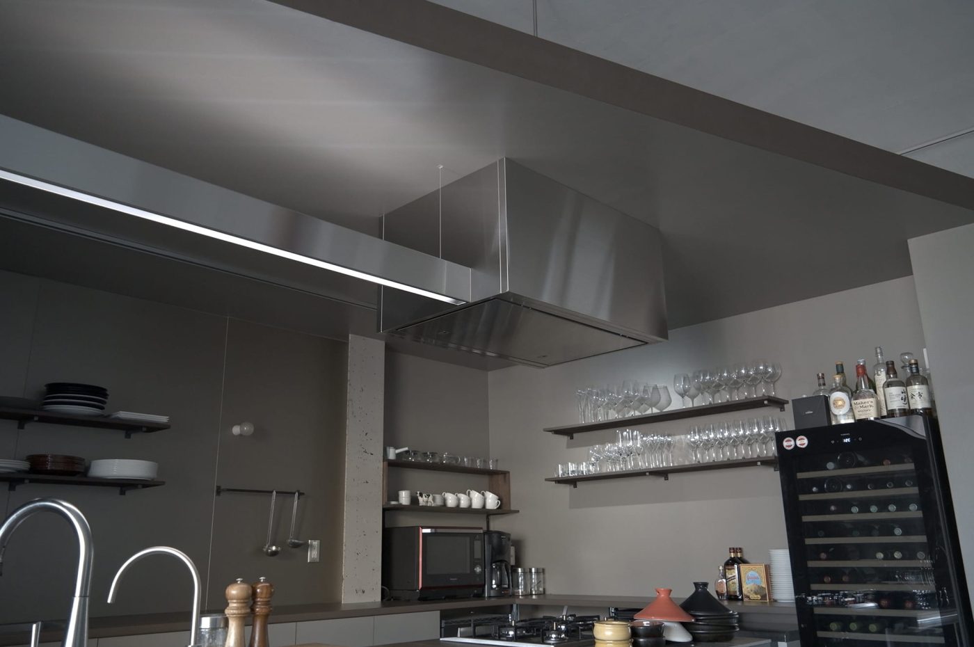 既製品のライン照明にステンレスのカバーをつけて、一体的なキッチン上空を演出。
