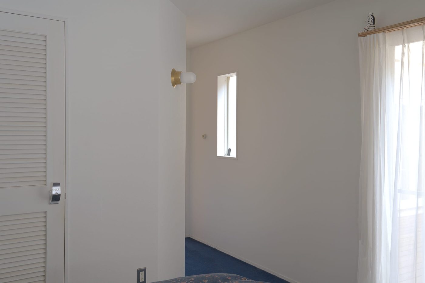 寝室から廊下へと続く空間を照らす照明として。ブルーのカーペットと真鍮は好相性。
