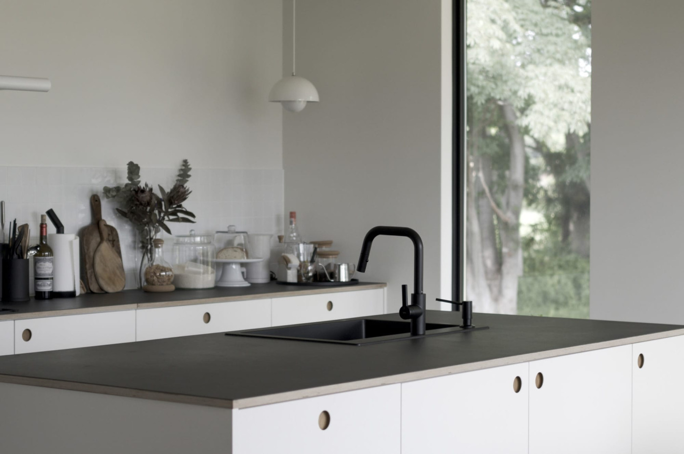 リノリウムの天板に水栓、シンクとマットなブラックで統一。設備感のない家具のような佇まいに。
