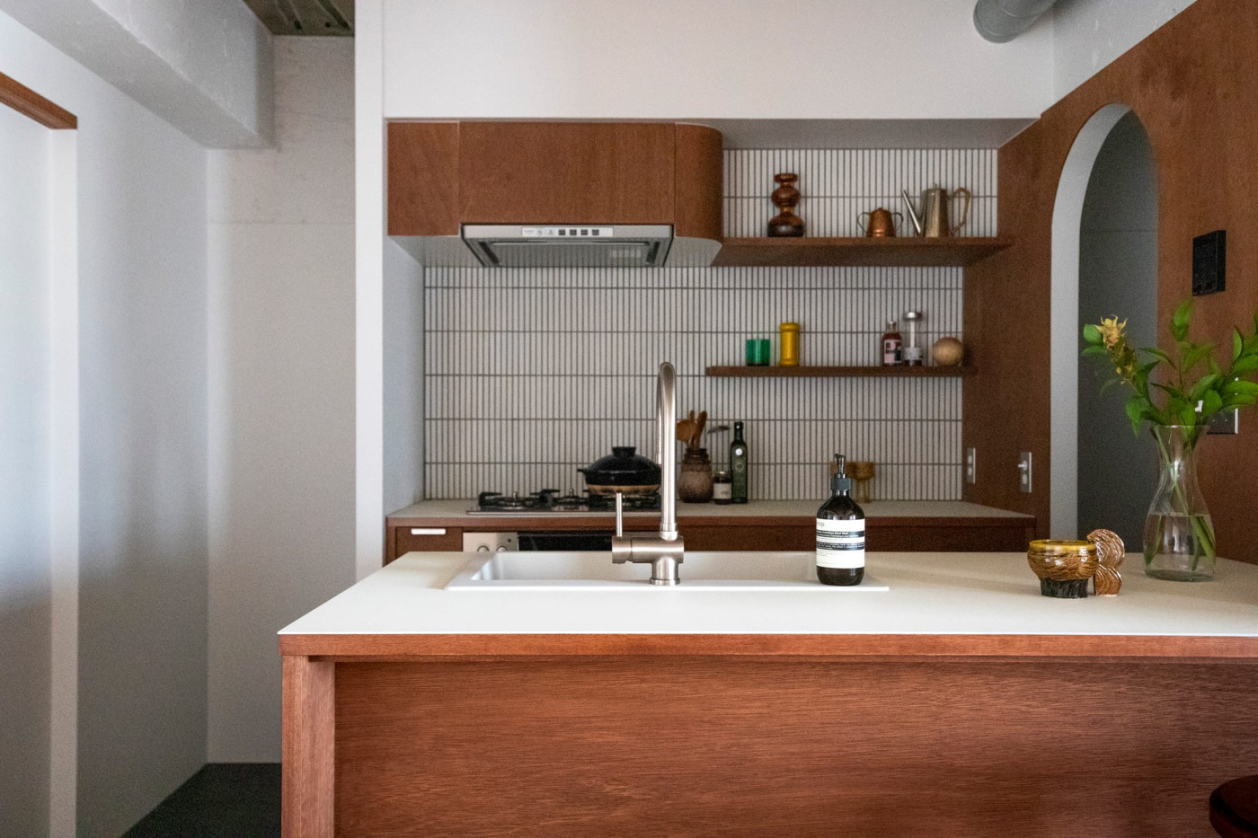 オープンなキッチンのリビング側から見たところ。木の白の組み合わせが印象的なキッチン。
