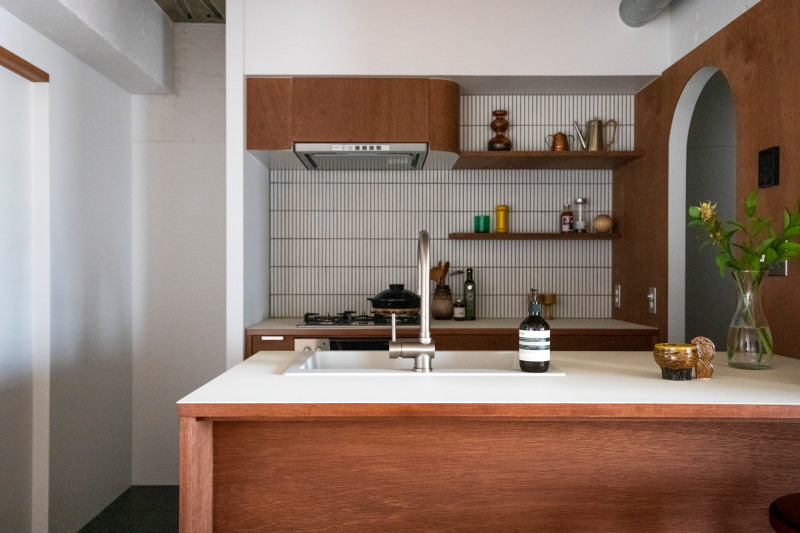 オープンなキッチンのリビング側から見たところ。木の白の組み合わせが印象的なキッチン。
