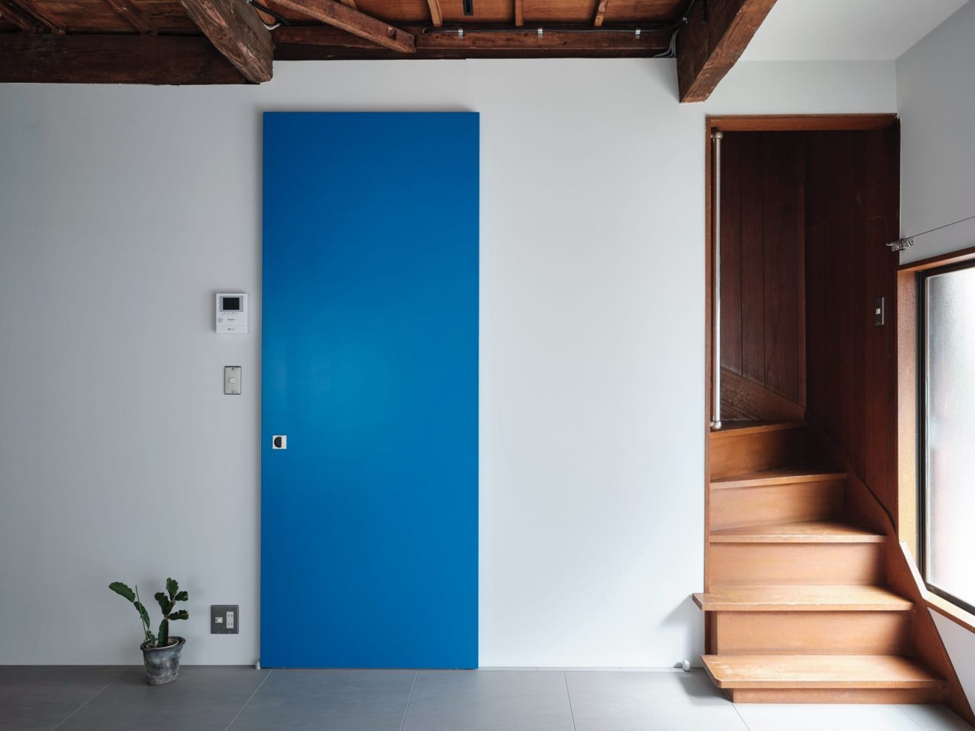 懐かしさを残した階段にビビッドなブルーのドアがグッドなバランス。（撮影：中村晃）