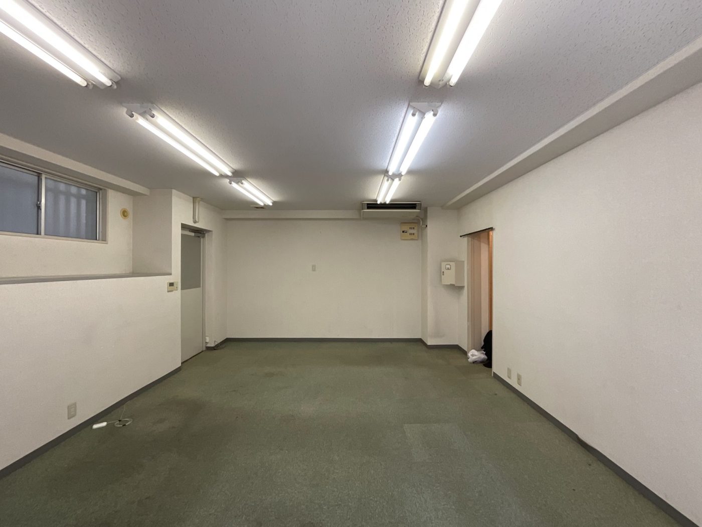 工事前の状態。天井は低く、床はタイルカーペットで、空間全体にも暗い印象を与えていました。