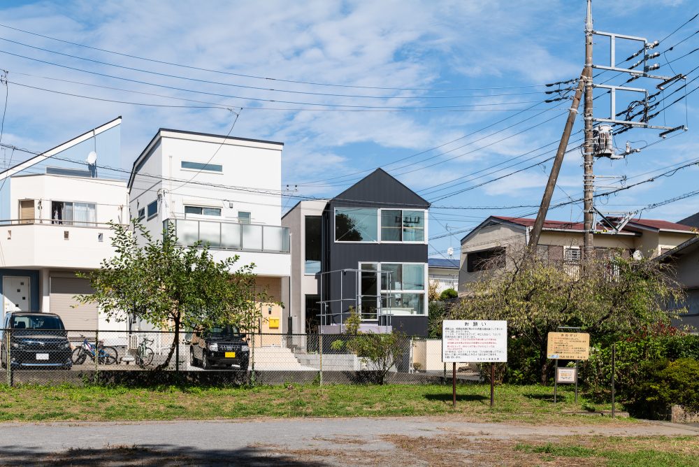 緑と街の景色を取り込む。角度をずらし組み合わされた二つのヴォリュームからなる家