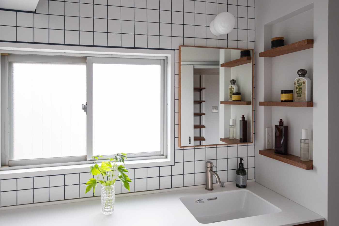 白とラワンで合わせた洗面空間に、ネイビーの目地を効かせて（75角）
