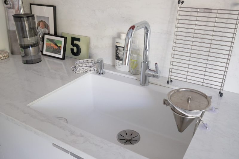 クォーツストーンの天板に合わせた事例。シンク脇の三角錐はゴミ受け！
