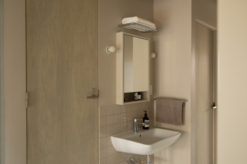 壁面にミラーが少し埋め込まれるように仕上げた、オープンな洗面。（サンドW460）
