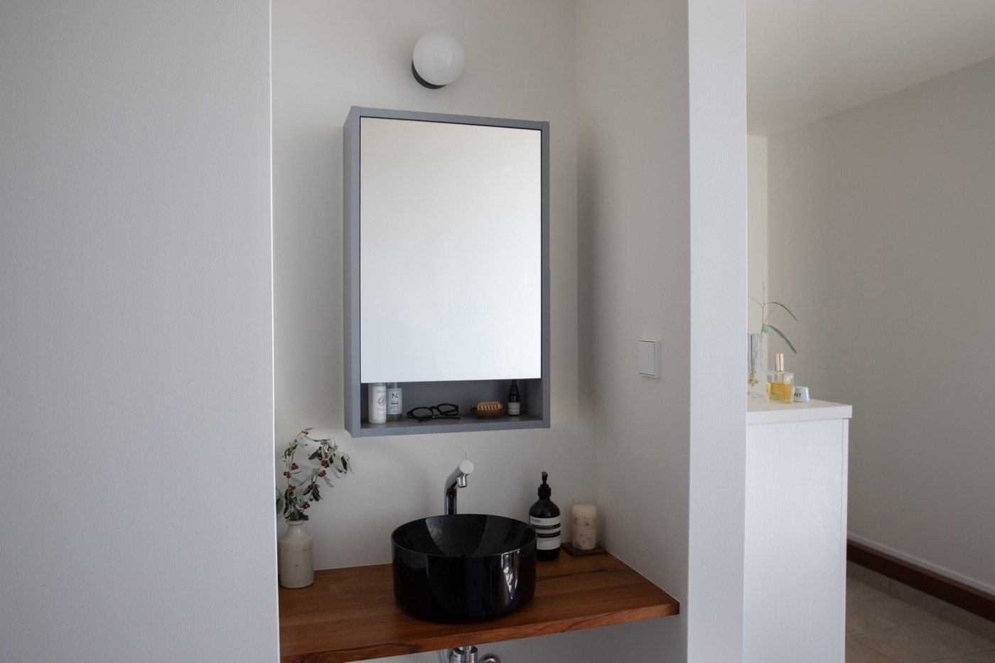 「いかにもな洗面ではなくギャラリーのように仕上げたい」という思いを叶えた、玄関入ってすぐの洗面。（グレーW460）
