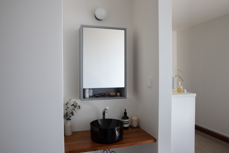 「いかにもな洗面ではなくギャラリーのように仕上げたい」という思いを叶えた、玄関入ってすぐの洗面。（グレーW460）
