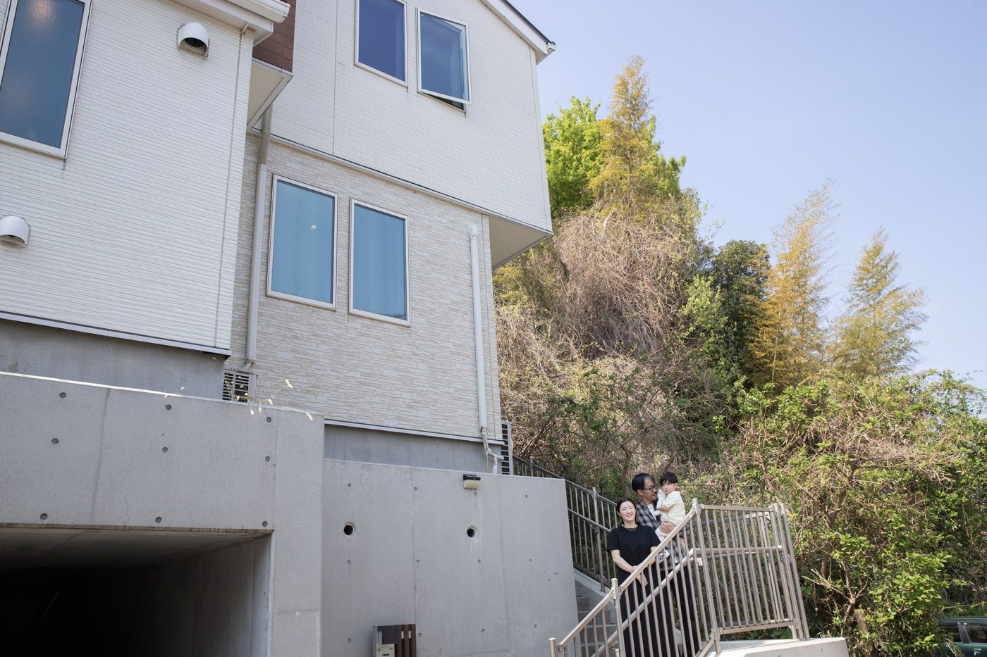 我が家は、駐車場を兼ねた基礎の上に建つ2階建ての木造住宅。1階のLDKからは隣の雑木林の緑が見えます。
