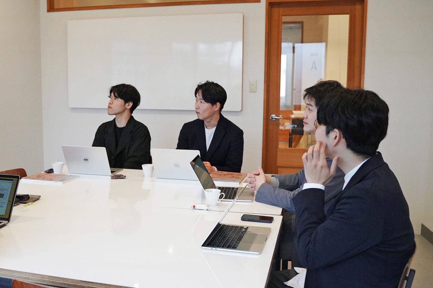 各チームのミッションを真剣に聞いている新卒スタッフ。手元に先輩が淹れたコーヒーを発見！