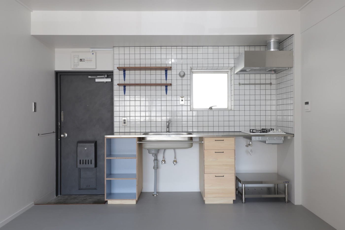 2人暮らしでも料理を楽しめる、爽やかでスッキリとしたキッチン。鉄扉は『アイアン塗料』で印象を変えています。