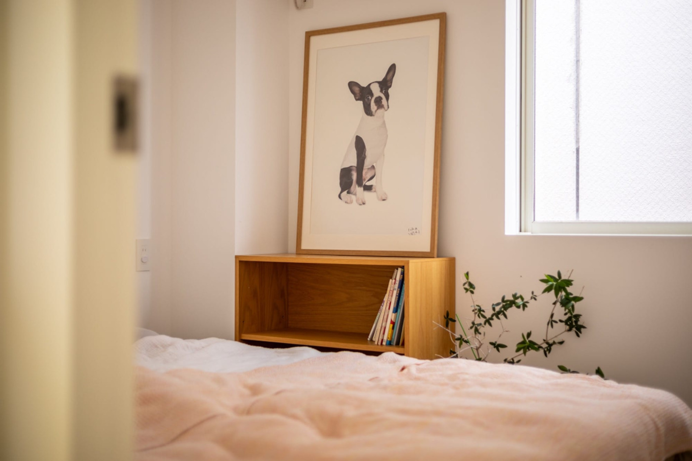 「寝るためだけ」と、クローゼットも別室にしっかり分けた寝室。柱に合わせて置かれた本棚やアートが、シンプルな空間に色を添えています。