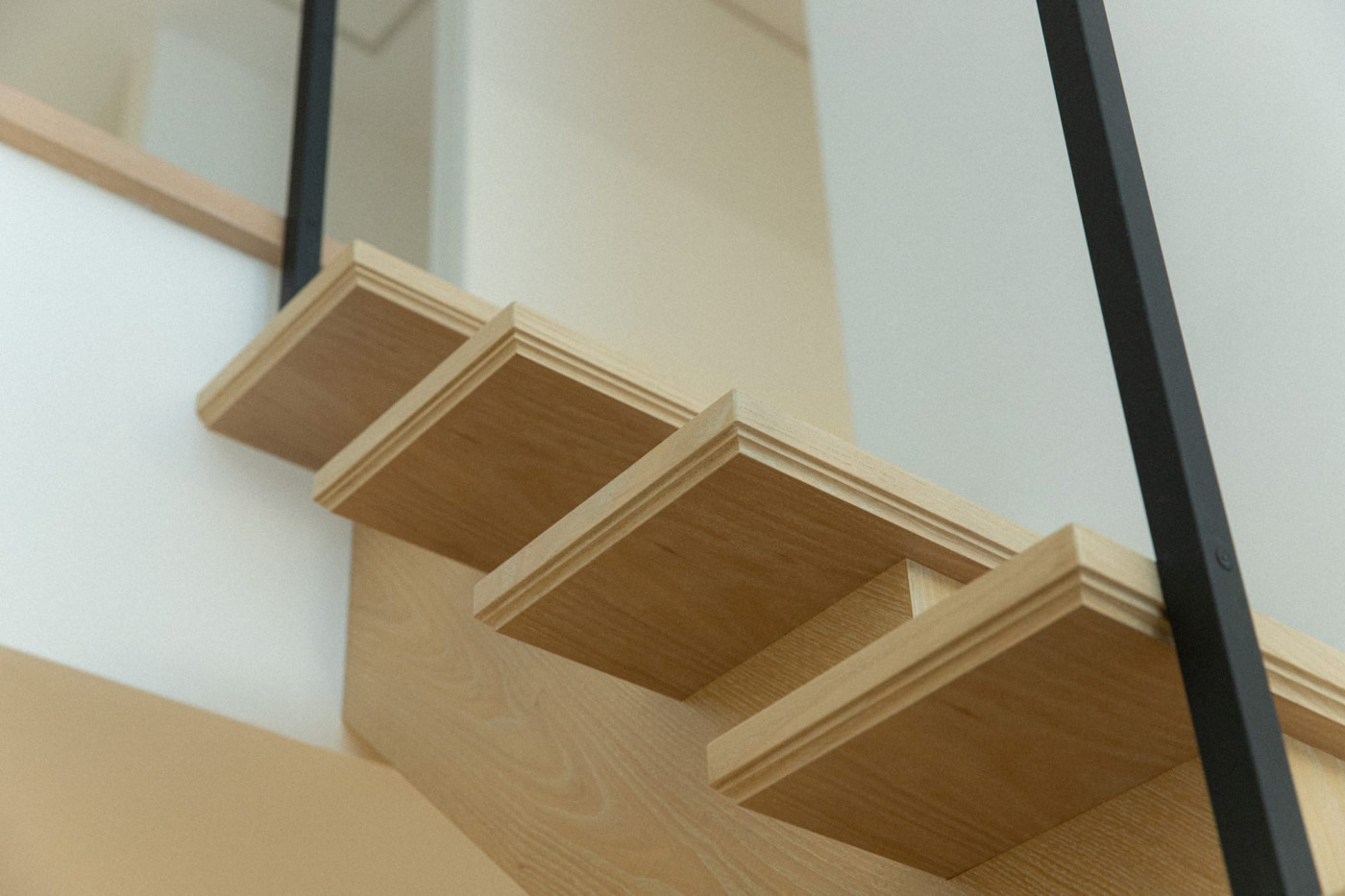 踏み板の縁取りは、少しでも薄く、軽やかに見えるようにと、細かいカッティングのついた装飾に。木作家さんがつくった額縁のよう。周りが白くシンプルな分、こだわりが引き立ちます。