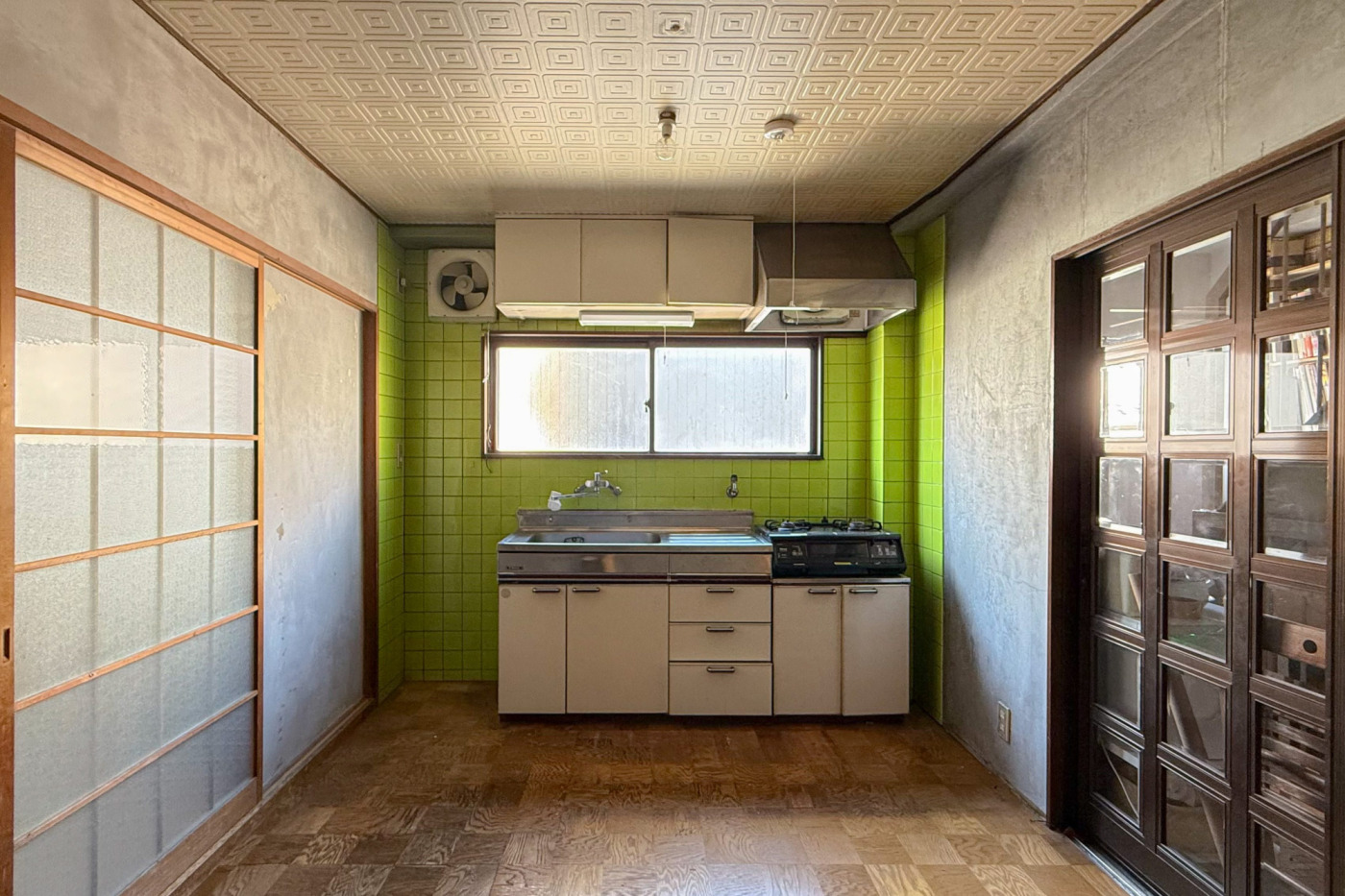 改装前のキッチン。今ではあまり見かけない、黄緑色のタイルが象徴的な場所でした。