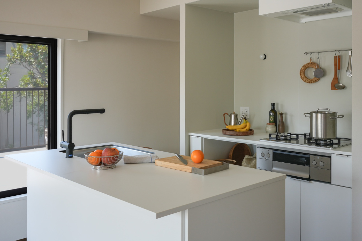 II型キッチンの​天板に​使用した​事例。整然とした​雰囲気の​漂う​キッチンに、​天板の​やわらかな​白と、​果物のは​っきりと​した​カラーの​コントラストが​気持ちいい。​（見付20 オフホワイト + スクエア520シンク）​
