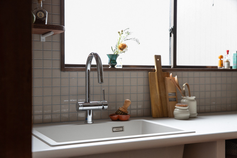 きらりとした​クロームの​輝きも、​つやりと​光る​タイルの​壁も、​梨地のような​マットな​質感の​天板が​光の​反射を​やさしく​受け止めているように​感じます。
