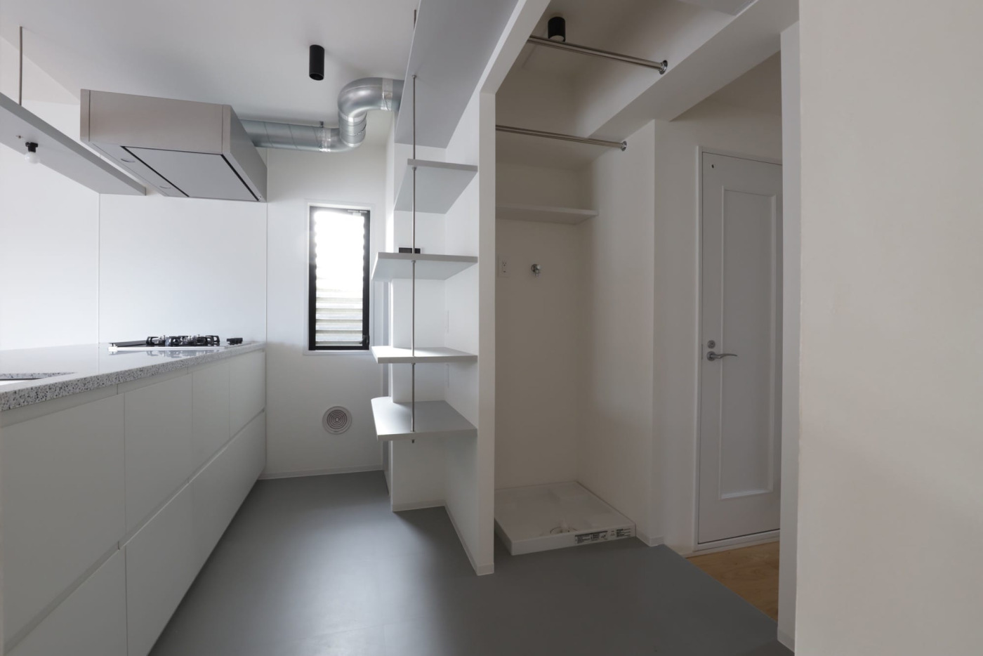 キッチン背面の洗濯スペース。キッチンはシンプルでフラットな『ユニキッチン』をセレクトしています。ベース照明は、キッチン室に『シーリングスポット』、洗濯スペースに『シーリングダウンライト』となっています。