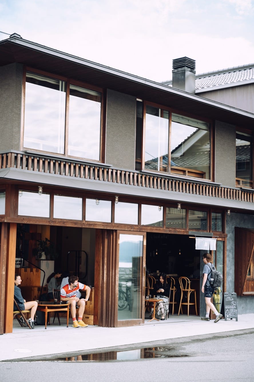 「SOIL Setoda LIVING」1階のまちに開いた食堂「 MINATOYA（ミナトヤ）」はラウンジスペースを兼ねている。2階は瀬戸内海を望むゲストルーム。（撮影：Hayate Tanaka）