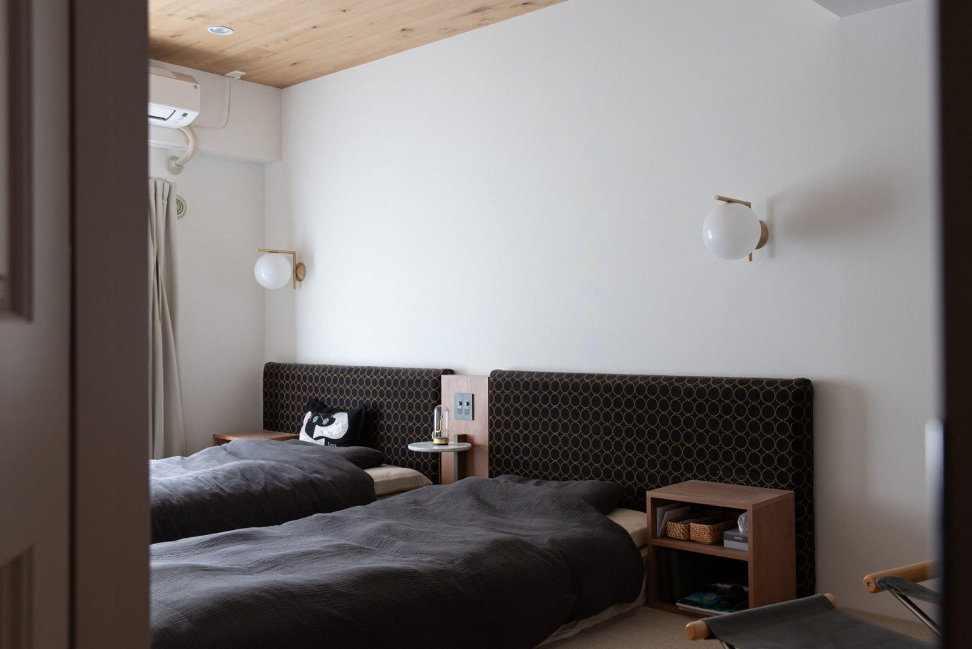 八ヶ岳のSANUの寝室など、滞在したホテルの設えを参考に。ベッドで本が読めるように棚は造作で、読書灯にもなるFLOSのウォールライトは、横になっても手が届く位置に調光スイッチを設けて。