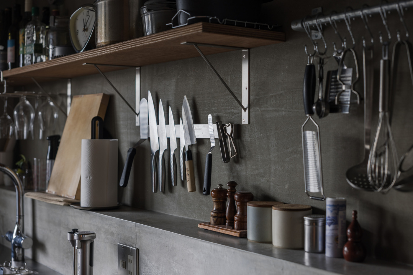 ラフな積層合板を軽やかに受け止める『棚受け金物』。モルタル壁との相性も◎