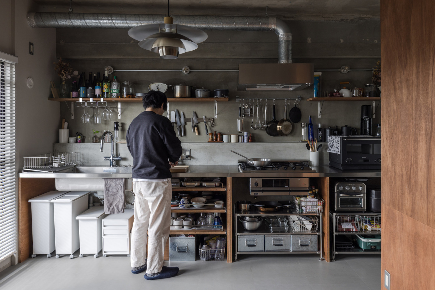 『フラットレンジフード』が、にぎやかな壁にすっと溶け込んでいます。重たいフライパンなどのツールはタフな『亜鉛メッキのマルチバー』に。