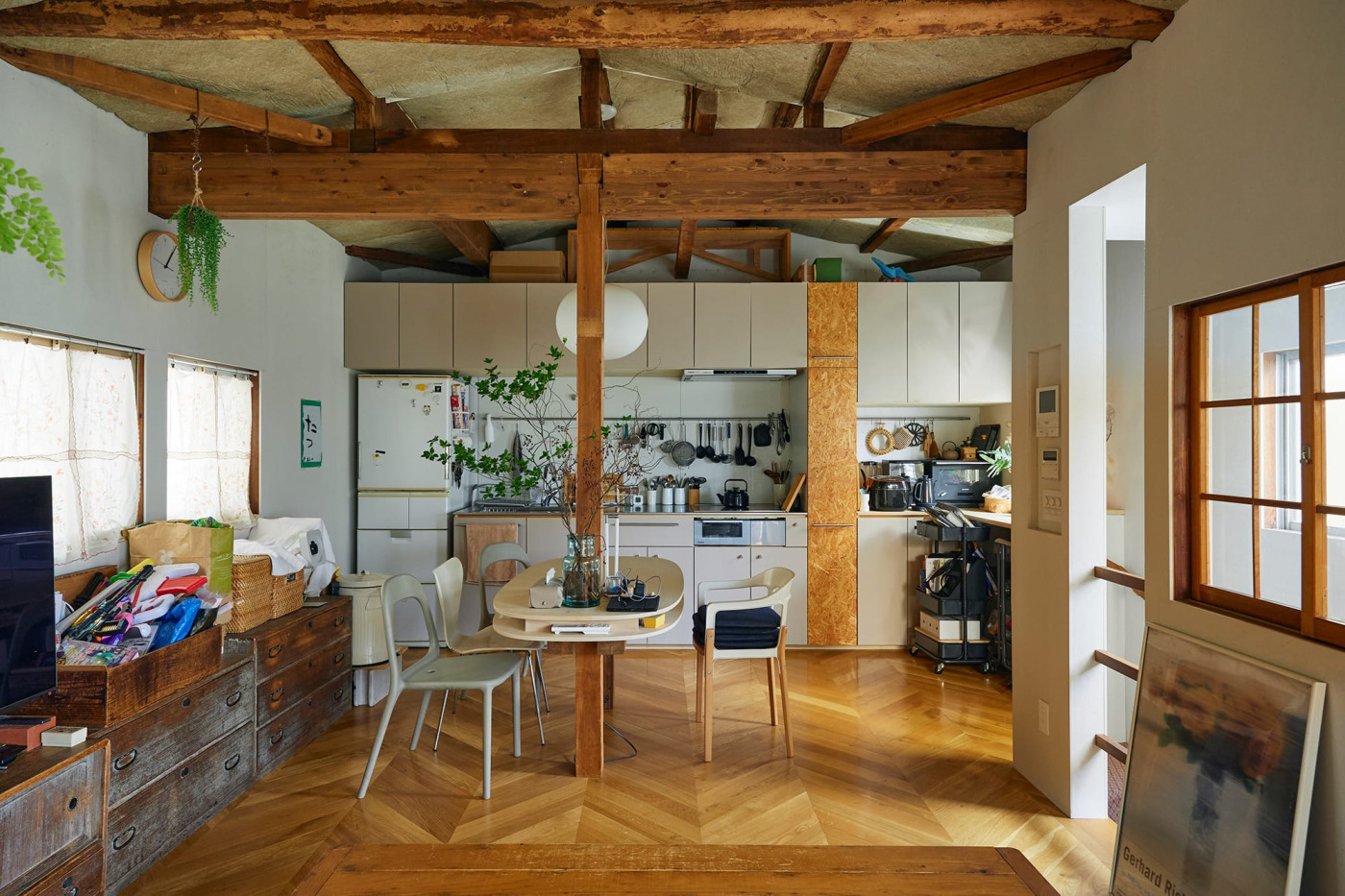 壁一面にすっきり納められた扉付き収納が印象的なキッチン。吊り戸棚にレンジフードが埋め込まれている。（事例協力：studio niko / 撮影：Masanori Kaneshita）