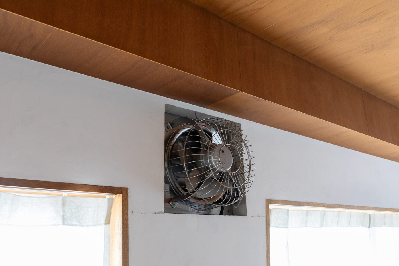 業務用の有圧換気扇。ステンレスのいかつい佇まいが特徴的。汚れが目に入るので半年に一度掃除する。