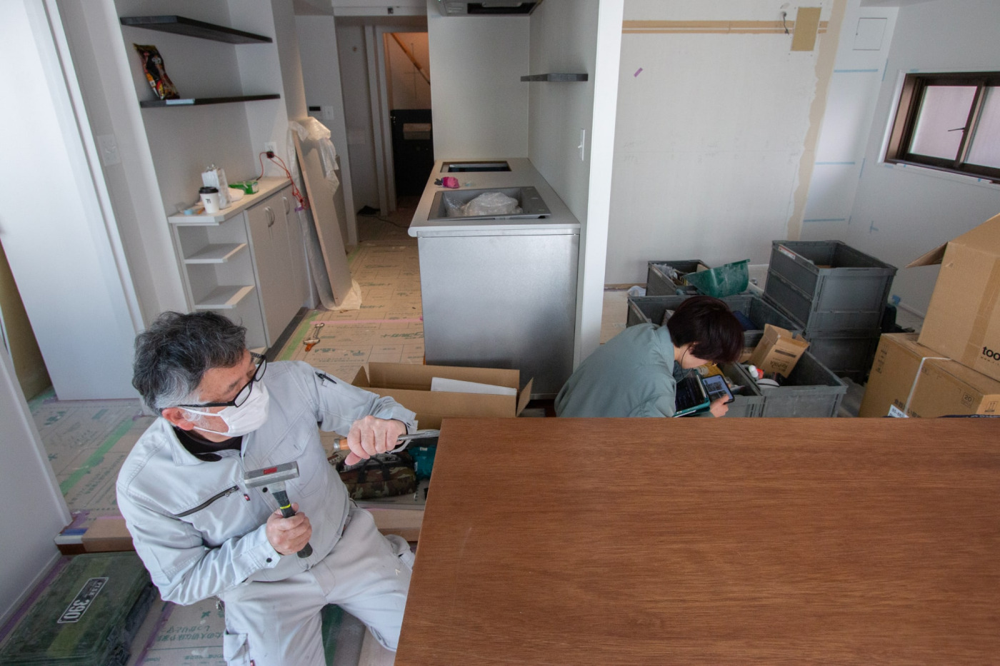 資材や工具の隙間で、山下がこっそりリモート会議をしていました。大事な最終局面、現場から離れられません！