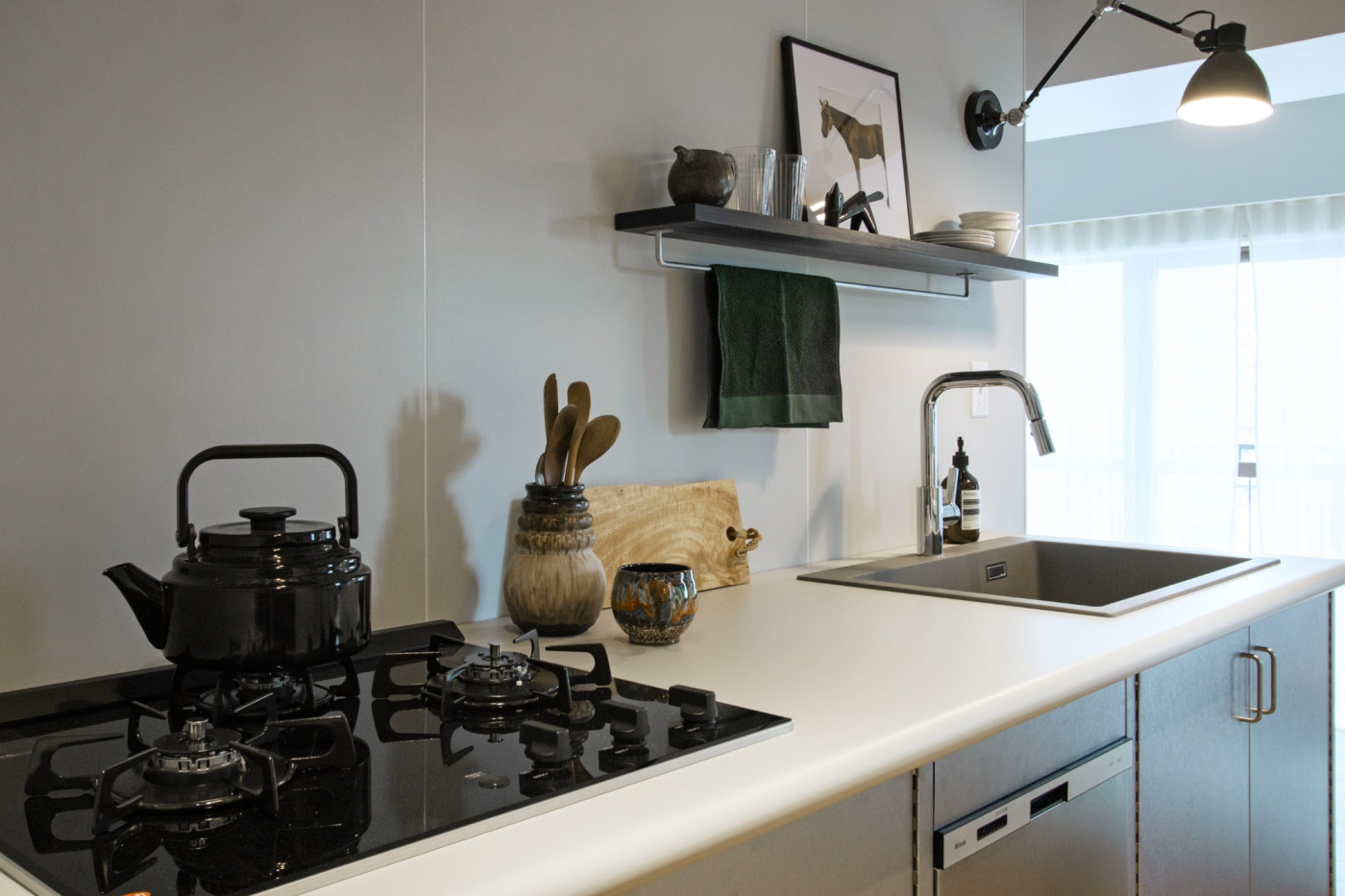 『マットカラーのキッチン天板』は丸い小口の「見付40」を使って家具的設えに。シンクは『クォーツシンク』で近日発売予定の新色グレー、手元灯には『インダストリアルアームライト』を使用。