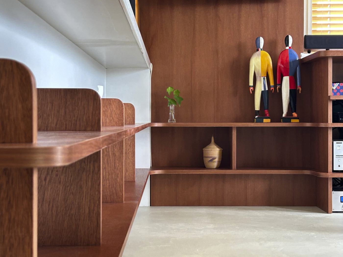 配線を隠すための収納。前板をモアビ突板で仕上げ壁面とフラットに見せています。