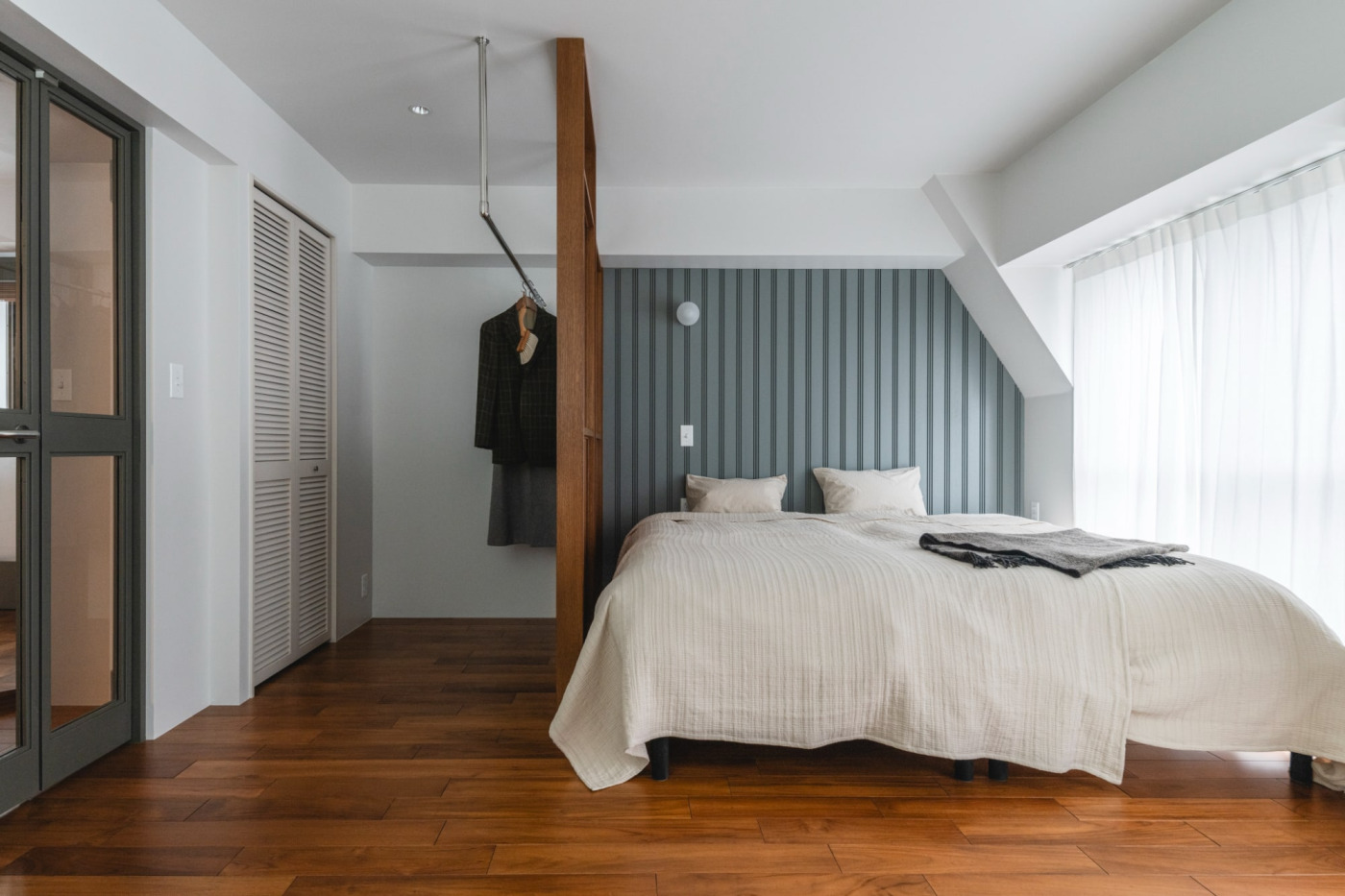 ベッド周りの壁にスリットパネルを貼って、寝床のコーナー感を高めました。（撮影：山下弘毅）