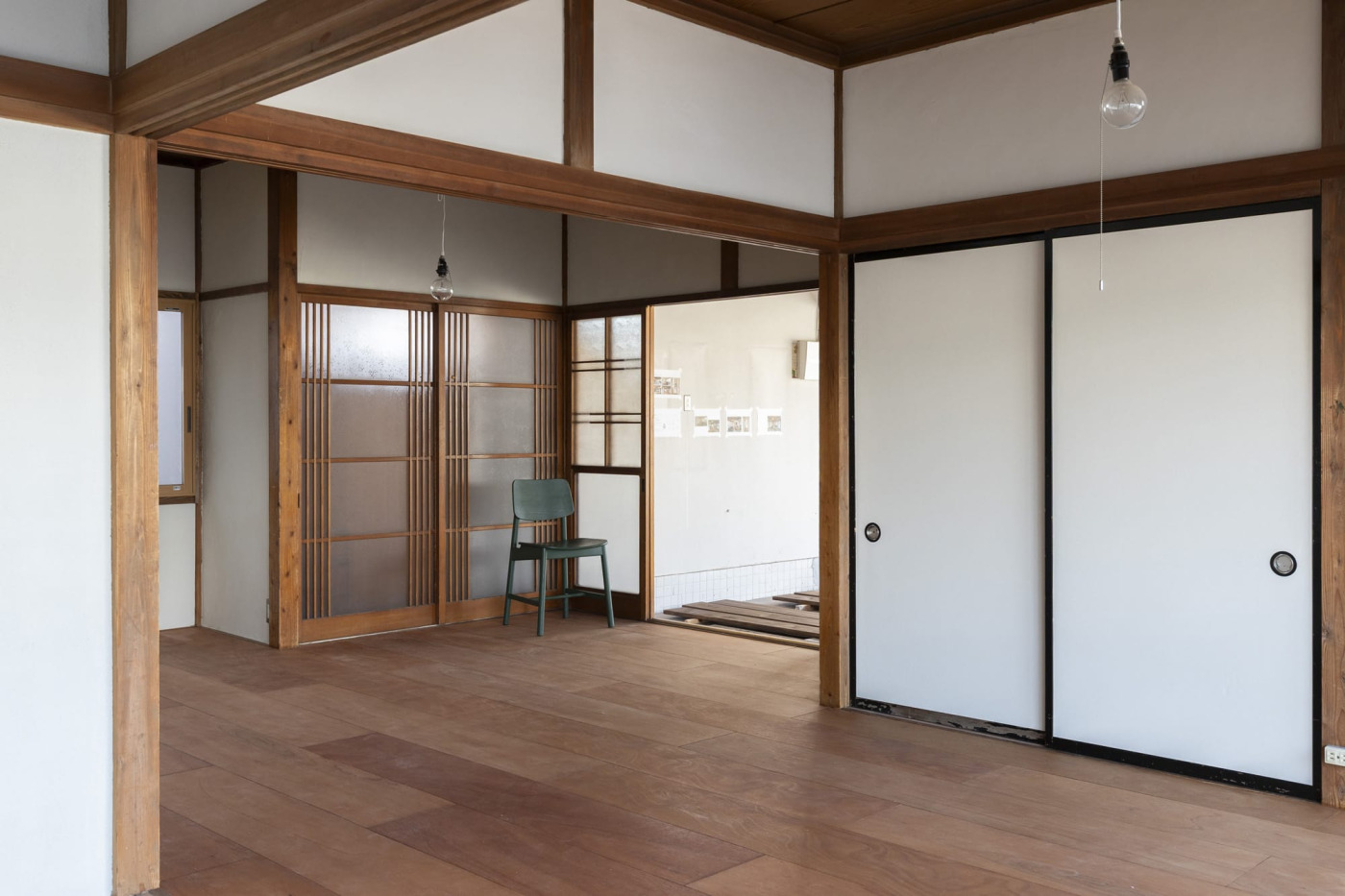 店舗区画との間のガラス戸を開けると、板間が広がるつくり。住居の入口も別にあります。