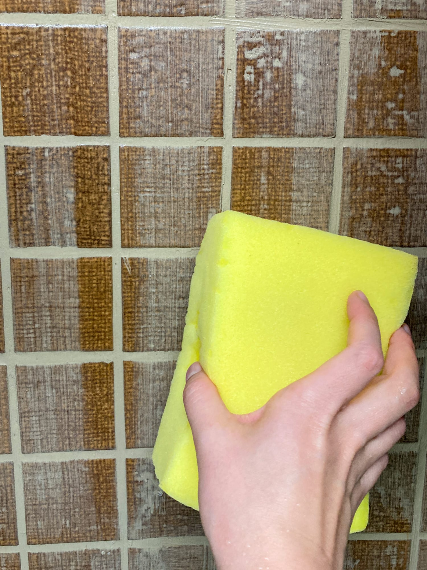水を絞ったスポンジで拭き上げていくところ。盛り上がっていた目地もこの時点で、フラットにならされていきます。