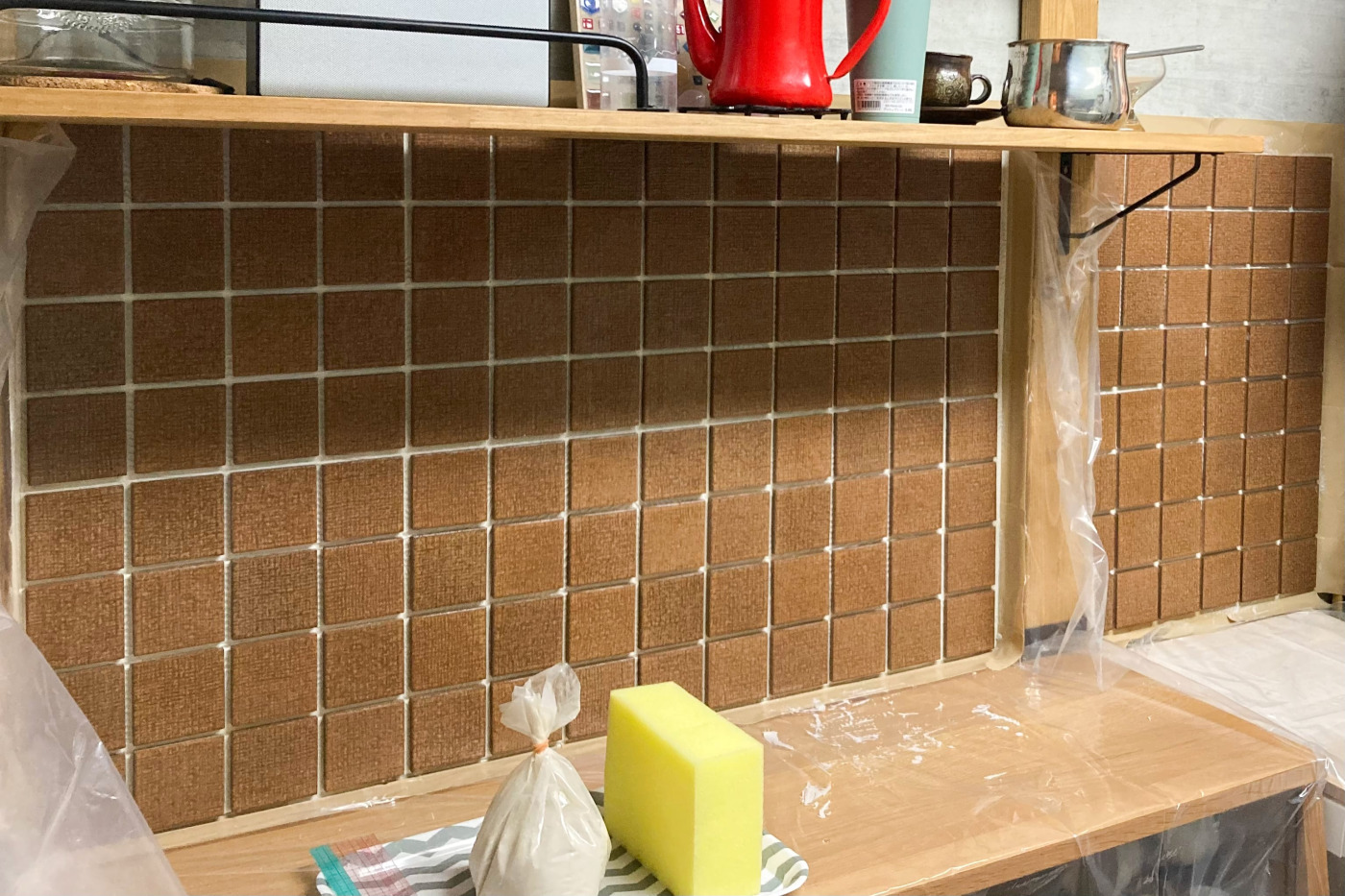 濡らしたスポンジでタイル表面をなでて裏紙をはがした、目地がつまっていない状態からスタート。