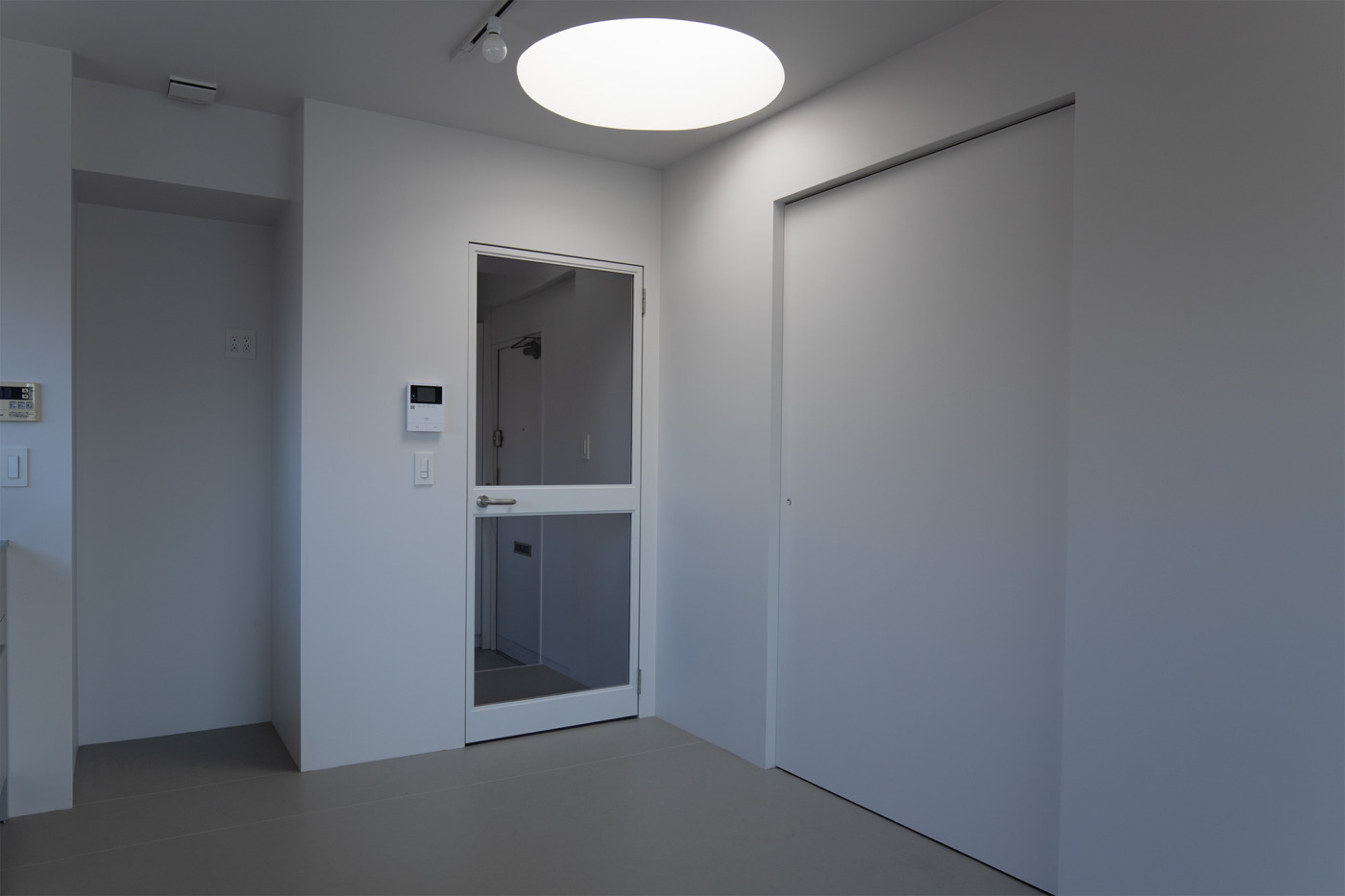LDK側にある印象的な天窓。LDK側の建具は『オーダースチールドア』を白く塗装し、右の個室の扉や壁とも雰囲気を合わせました。