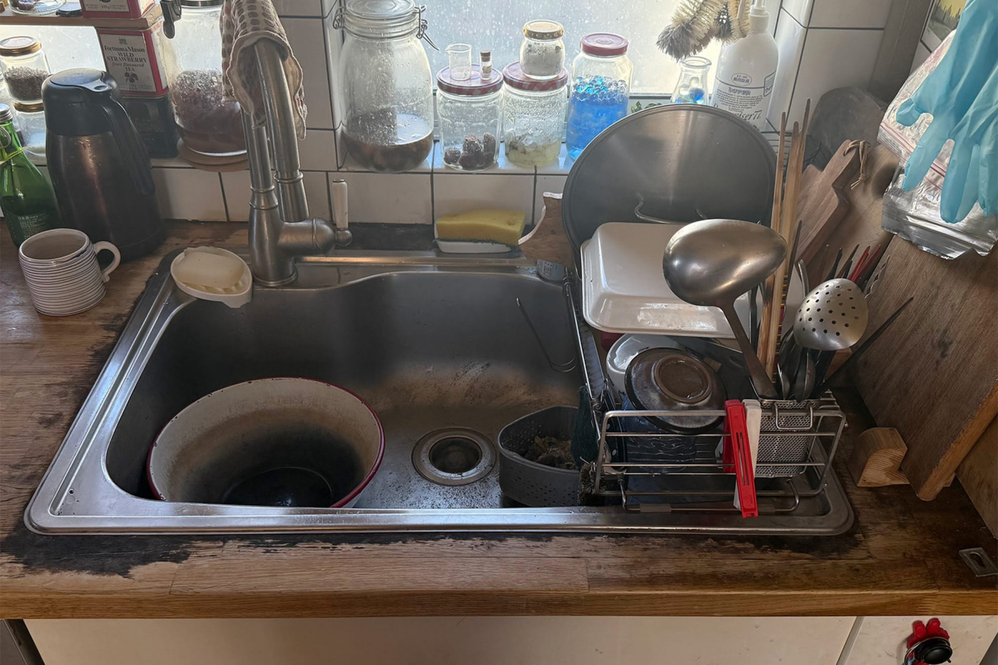 Before：木の天板がつくる温かみのあるキッチン。一方で、シンクまわりは痛みが進んでいました。